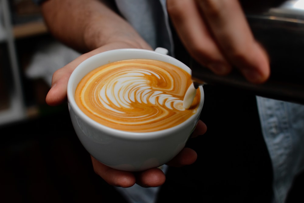 ラテアートが描かれたカフェラテのカップ