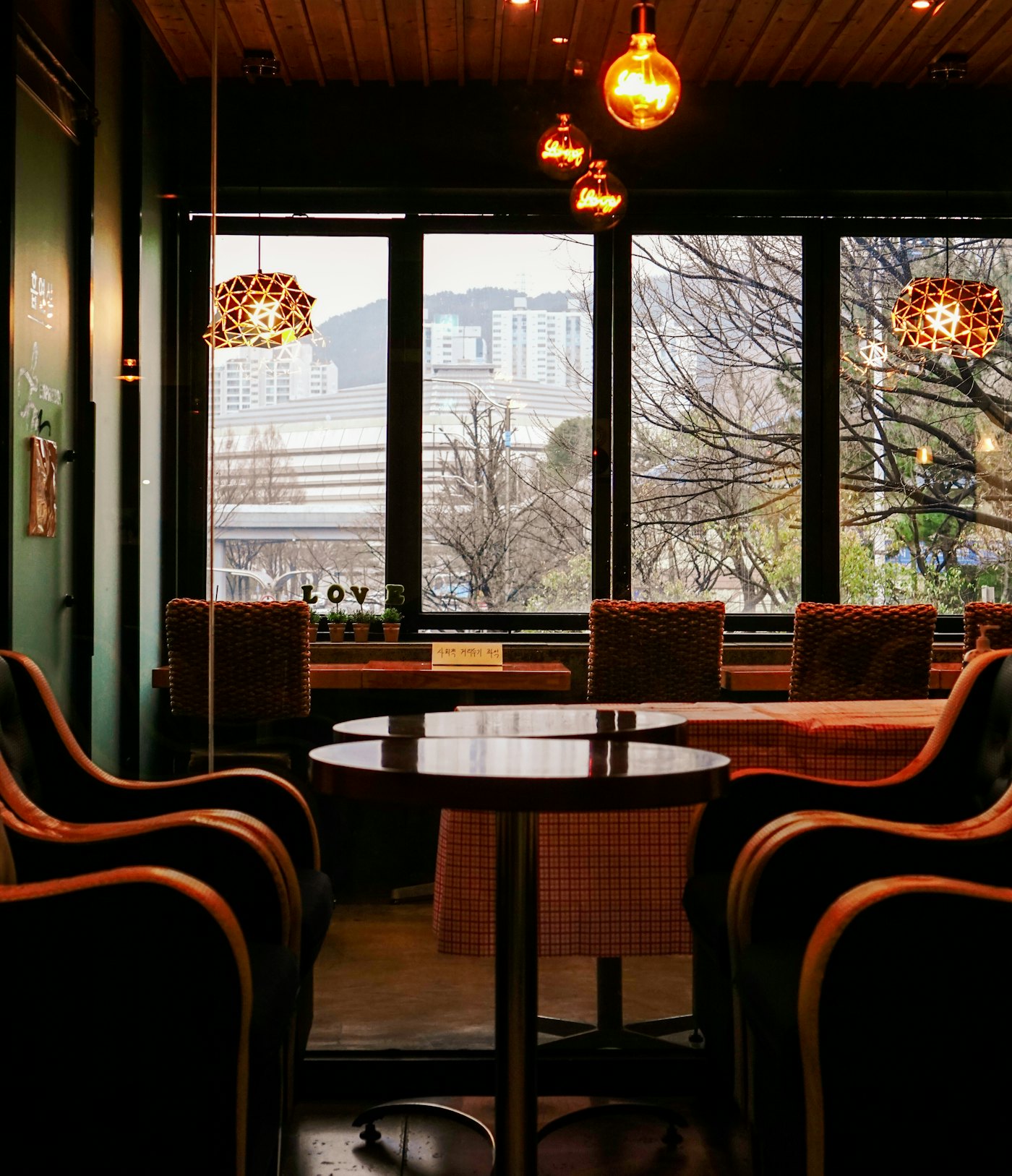 白い壁とアーチ窓、入口に緑を添えた Petit Marché の外観